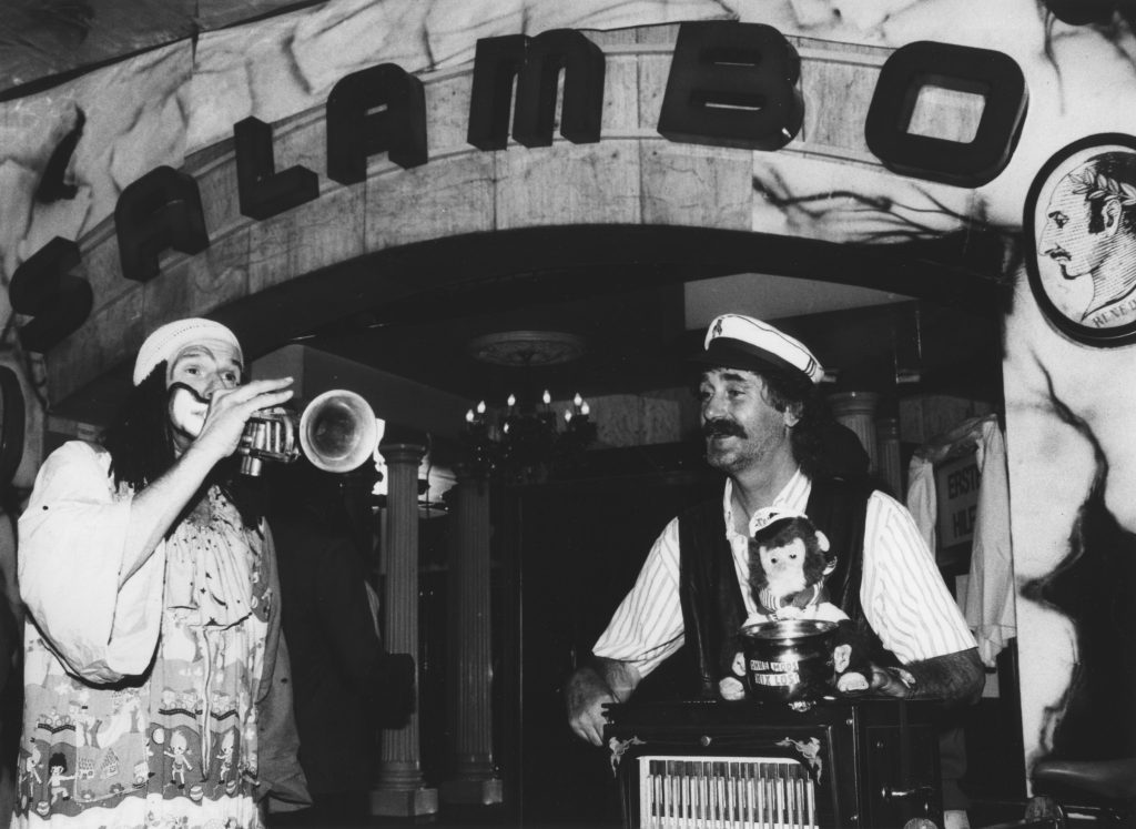 Aussenaufnahme Protestaktion vor Eingang Salambo mit Clown mit Trompete und Drehorgelspieler